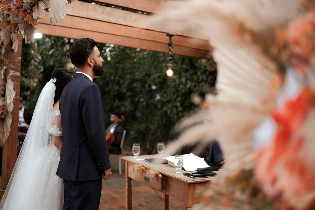 Momentos espontâneos dos noivos durante a cerimônia ao ar livre em Santa Luzia, Minas Gerais, mostrando a alegria e emoção do casamento.

