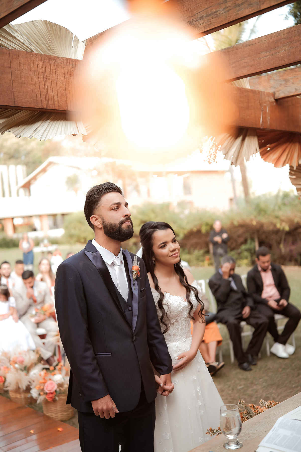 Momentos espontâneos dos noivos durante a cerimônia ao ar livre em Santa Luzia, Minas Gerais, mostrando a alegria e emoção do casamento.

