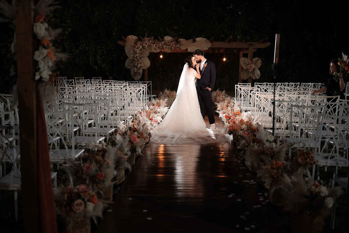 Detalhes do casamento no campo, com foco nas alianças, flores e decoração rústica, capturando a essência do grande dia.