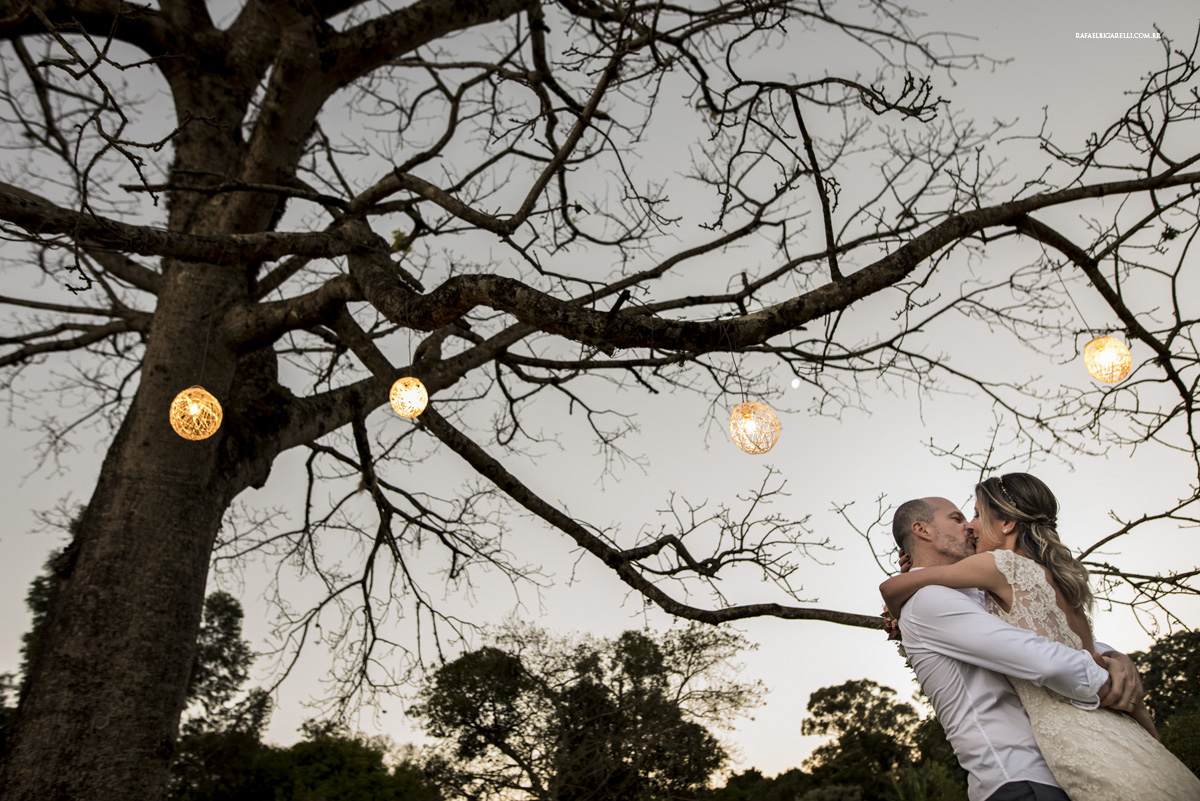 noivos se beijando luzes arvore