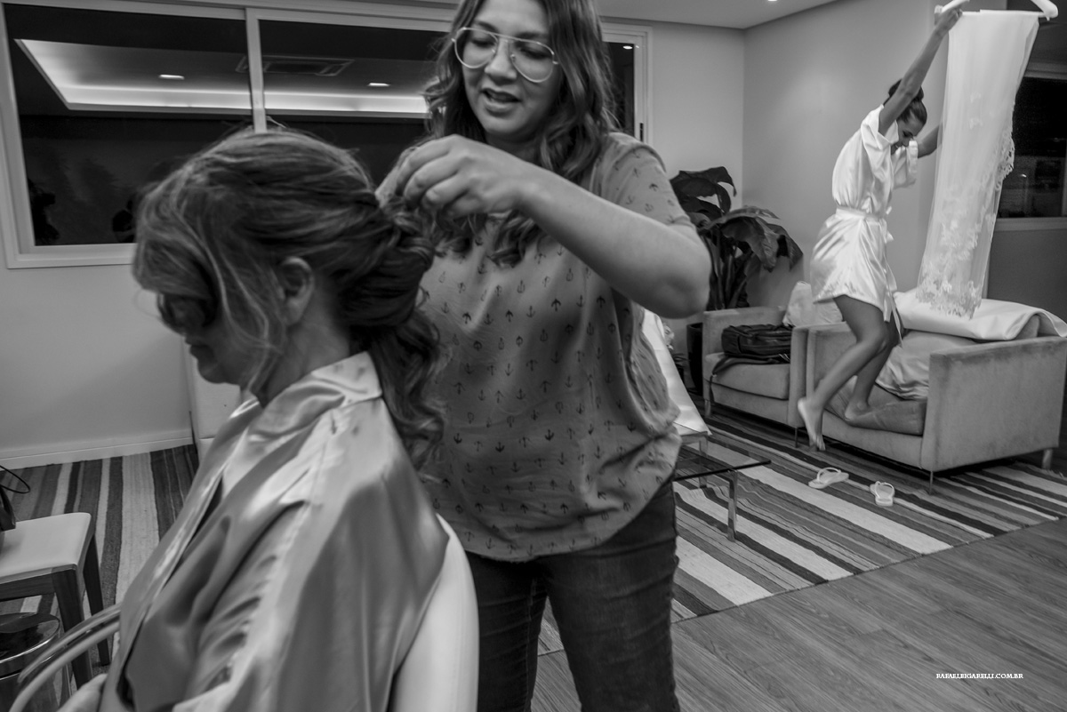 noiva subindo na cadeira para pegar o seu véu