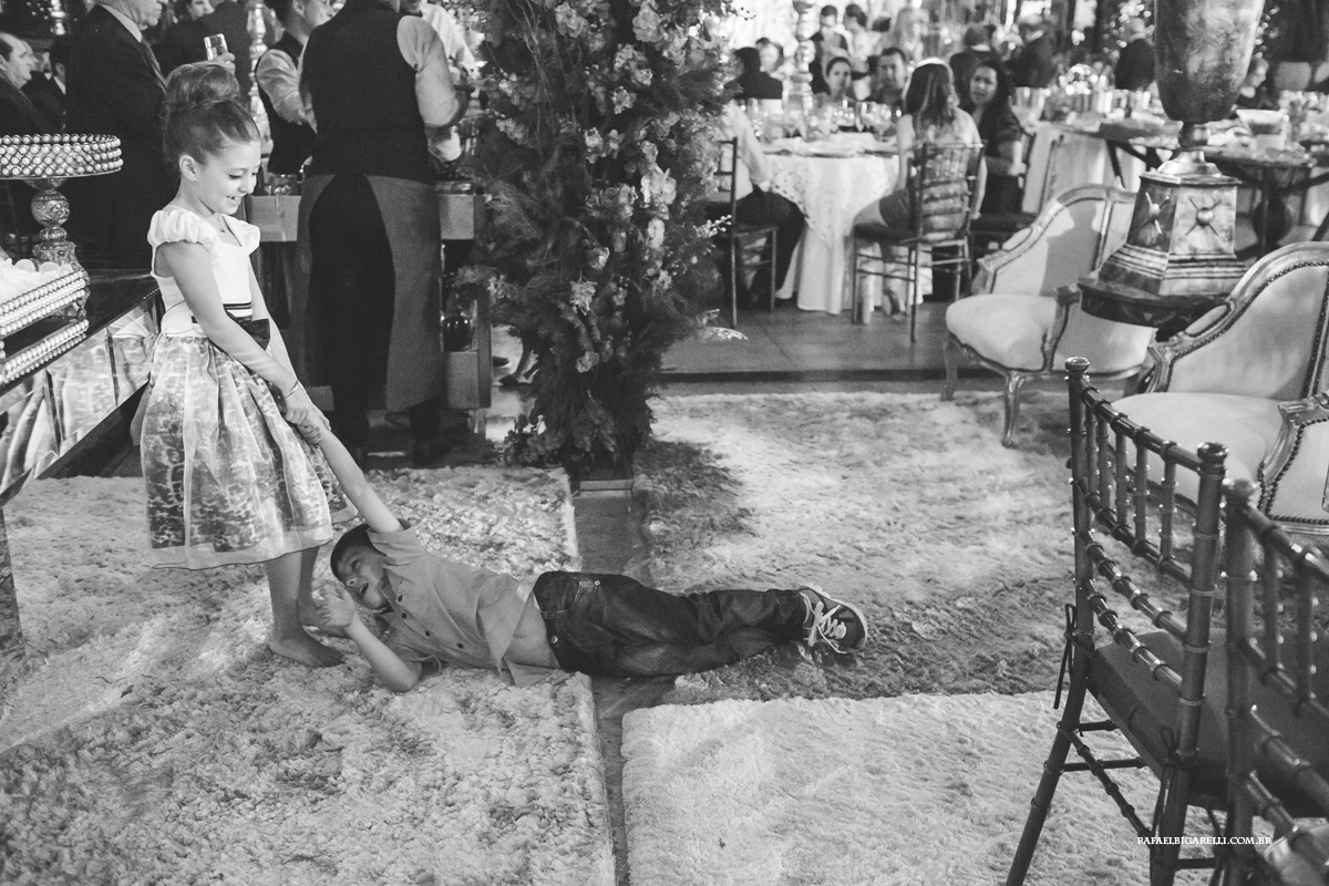 menina arrastando o menino pela festa do casamento