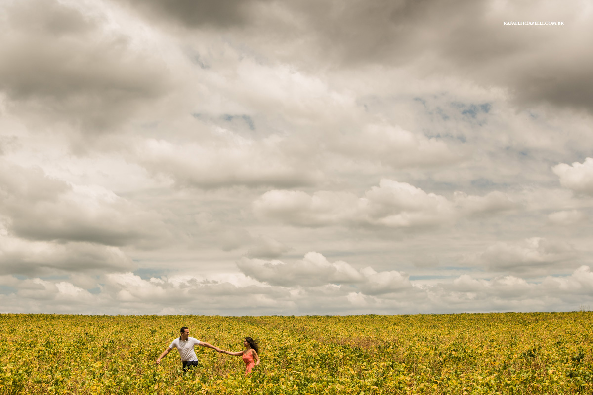 noivos correndo no descampado em sessão de pre casamento