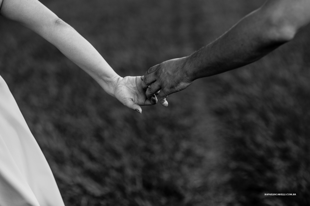 casal de mãos dadas com fundo desfocado