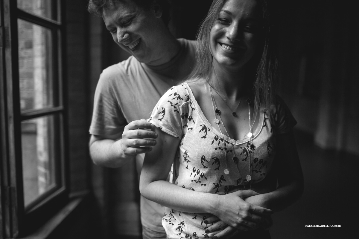 noivos sorrindo ao lado da janela