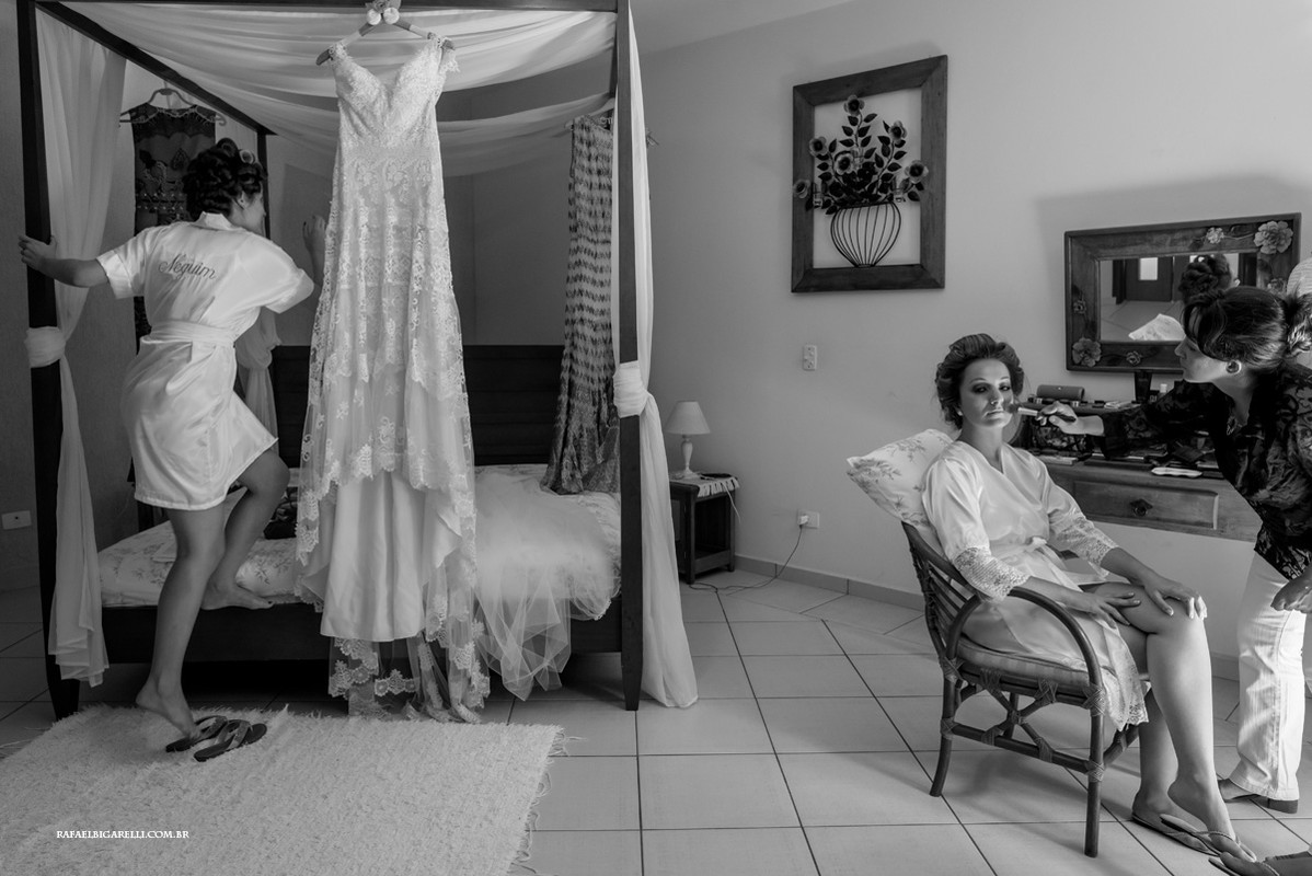 noiva se arrumando e sua irma arrumando o vestido em cima da cama