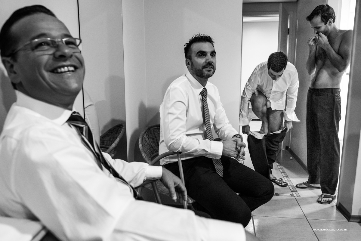 amigos do noivo se arrumam junto no quarto de hotel