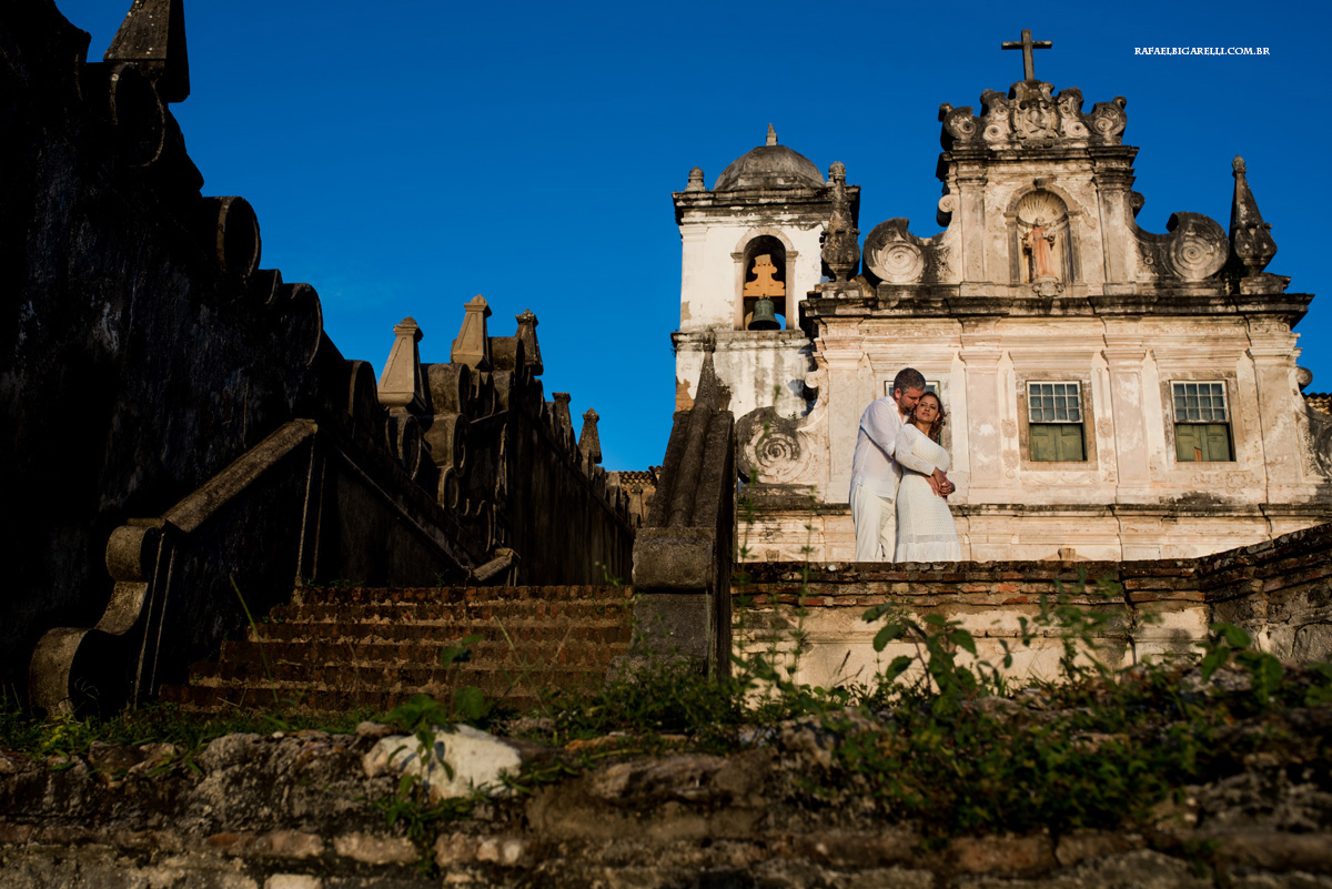 noivos se abraçam em frente a igreja