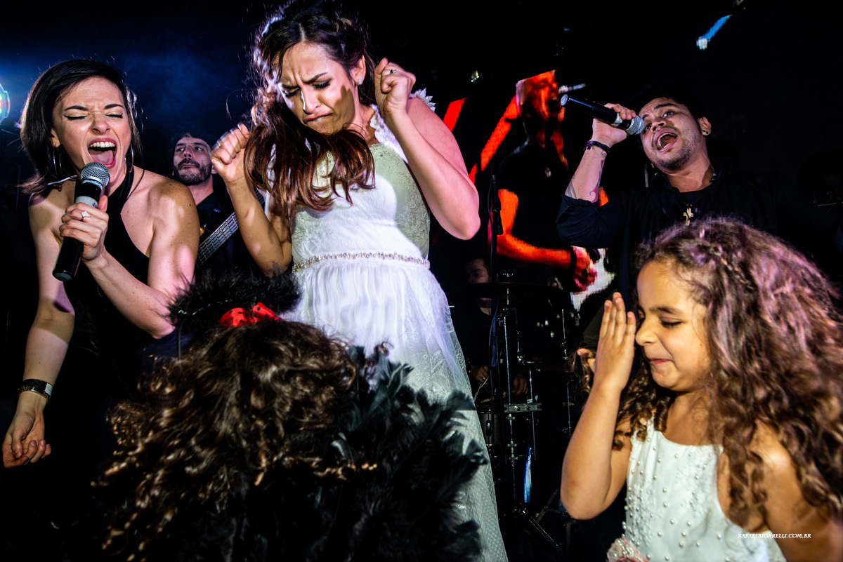 noiva no palco com banda em festa de casmento no beach hotel cambury na praia de cambury são sebastião sp fotógrafo rafael bigarelli