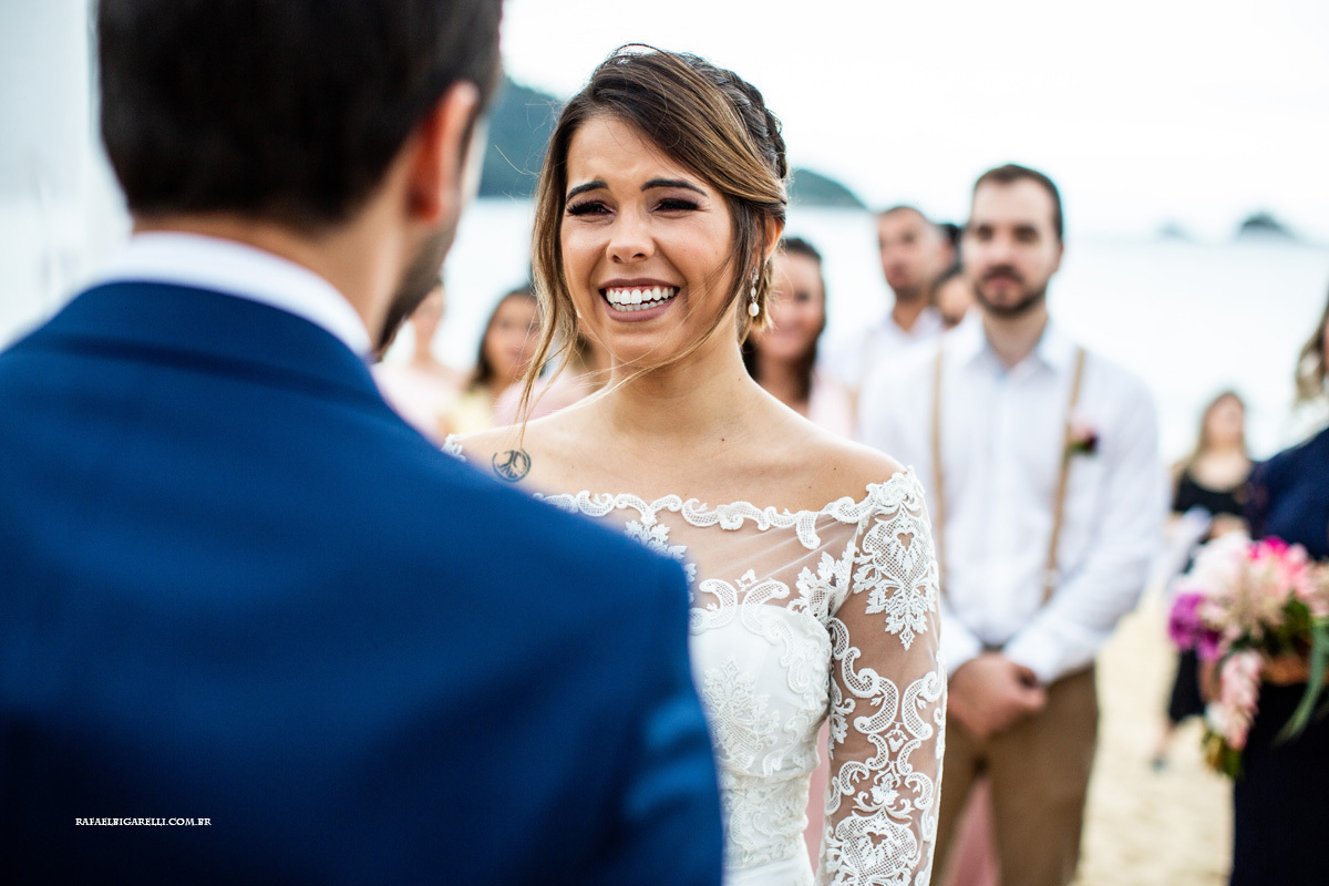 noiva sorrindo para o noivo em cerimônia ao ar livre casamento na praia em toque toque pequeno litoral de são paulo fotógrafo rafael bigarelli