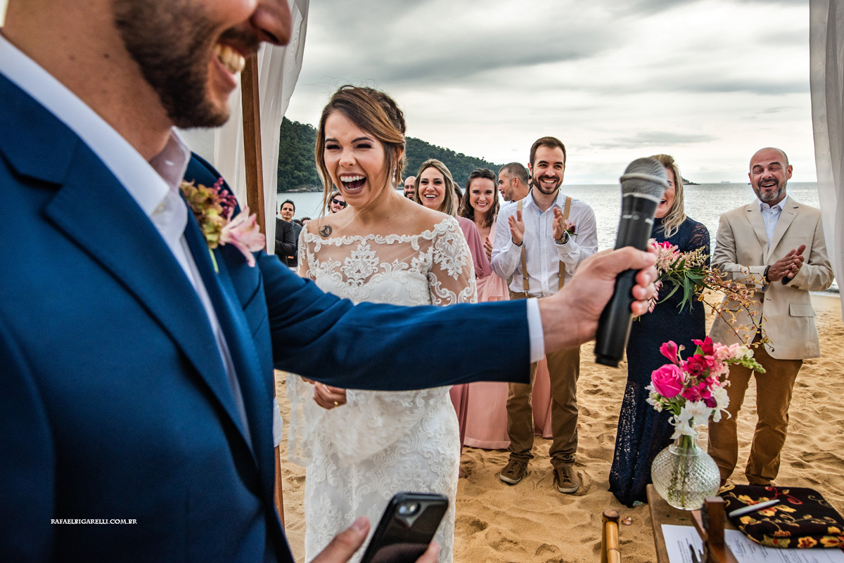 reação da noiva sorrindo em cerimônia ao ar livre casamento na praia em toque toque pequeno litoral de são paulo fotógrafo rafael bigarelli