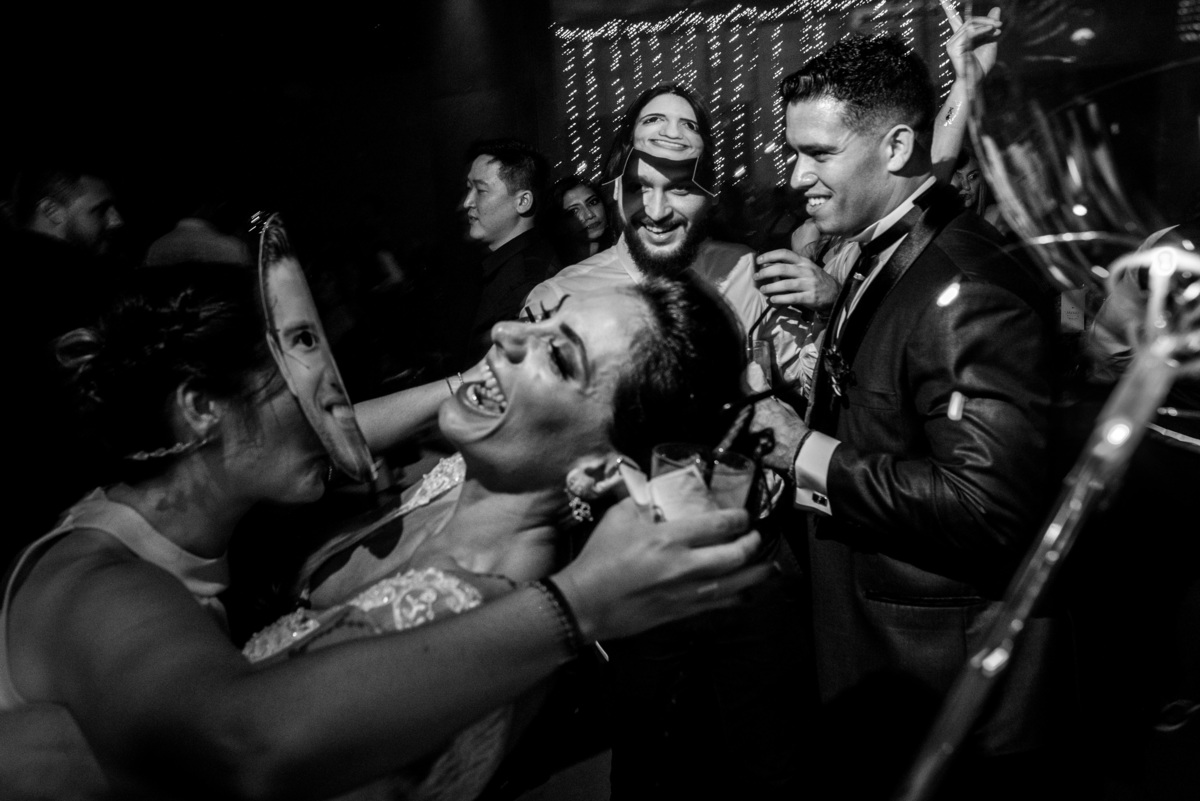 noivos se divertindo noiva beija convidado com máscara do noivo em casamento santo andré sp fotógrafo rafael bigarelli