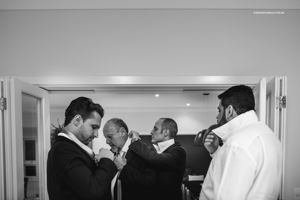 noivo junto com seu pai e irmãos se arrumando para o casamento