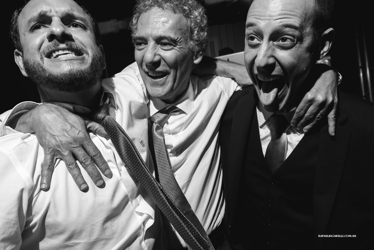 noivo pulando com seu pai e irmão