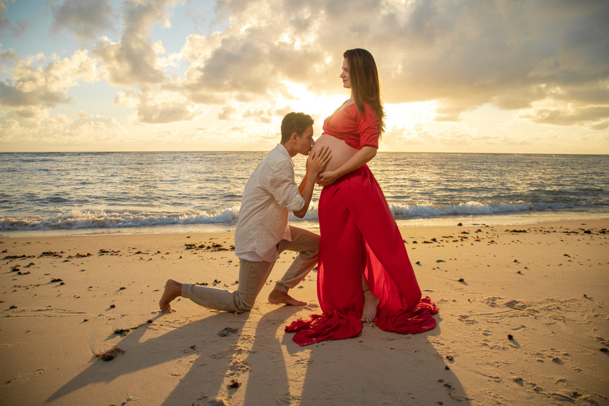 Filho beija barriga da mãe pose ensaio de gestante
