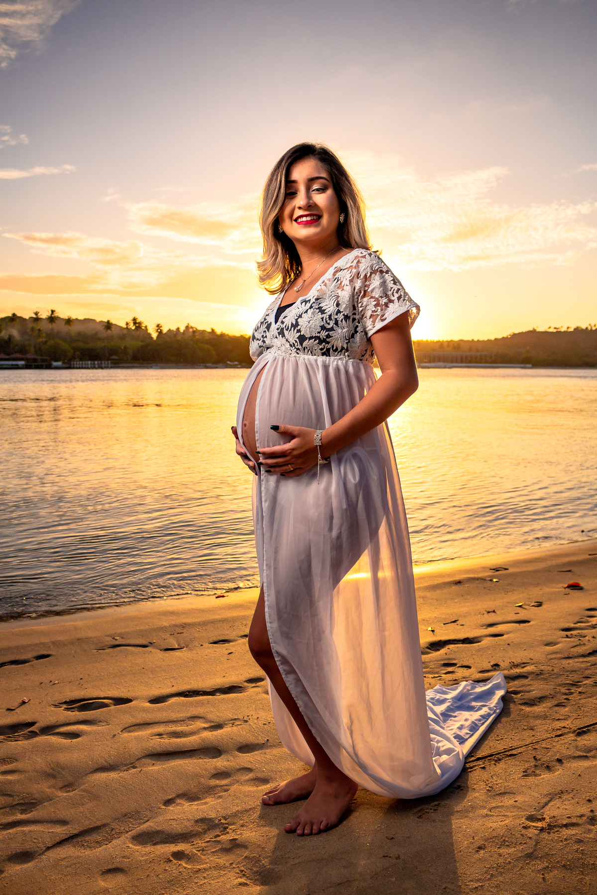 Gestante vestida de branco sorrindo