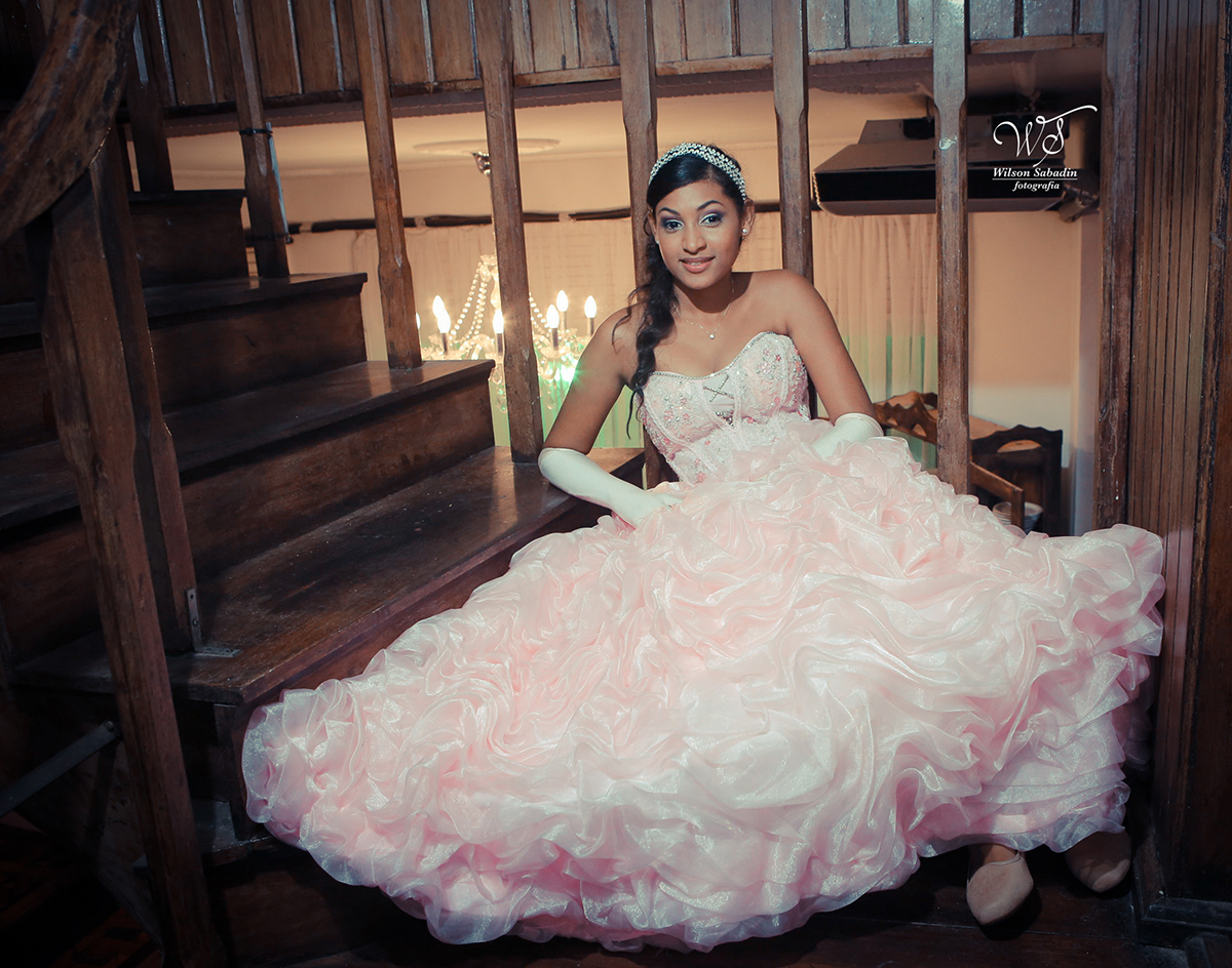 fotografia de 15 a debutante sentada na escada de madeira colonial