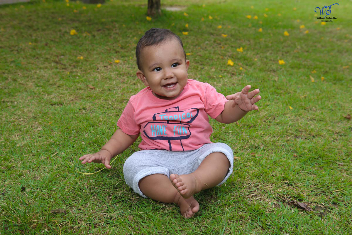 Fotografia infantil em Salvador Bahia Enzo sentado na grama do Parque da Cidade