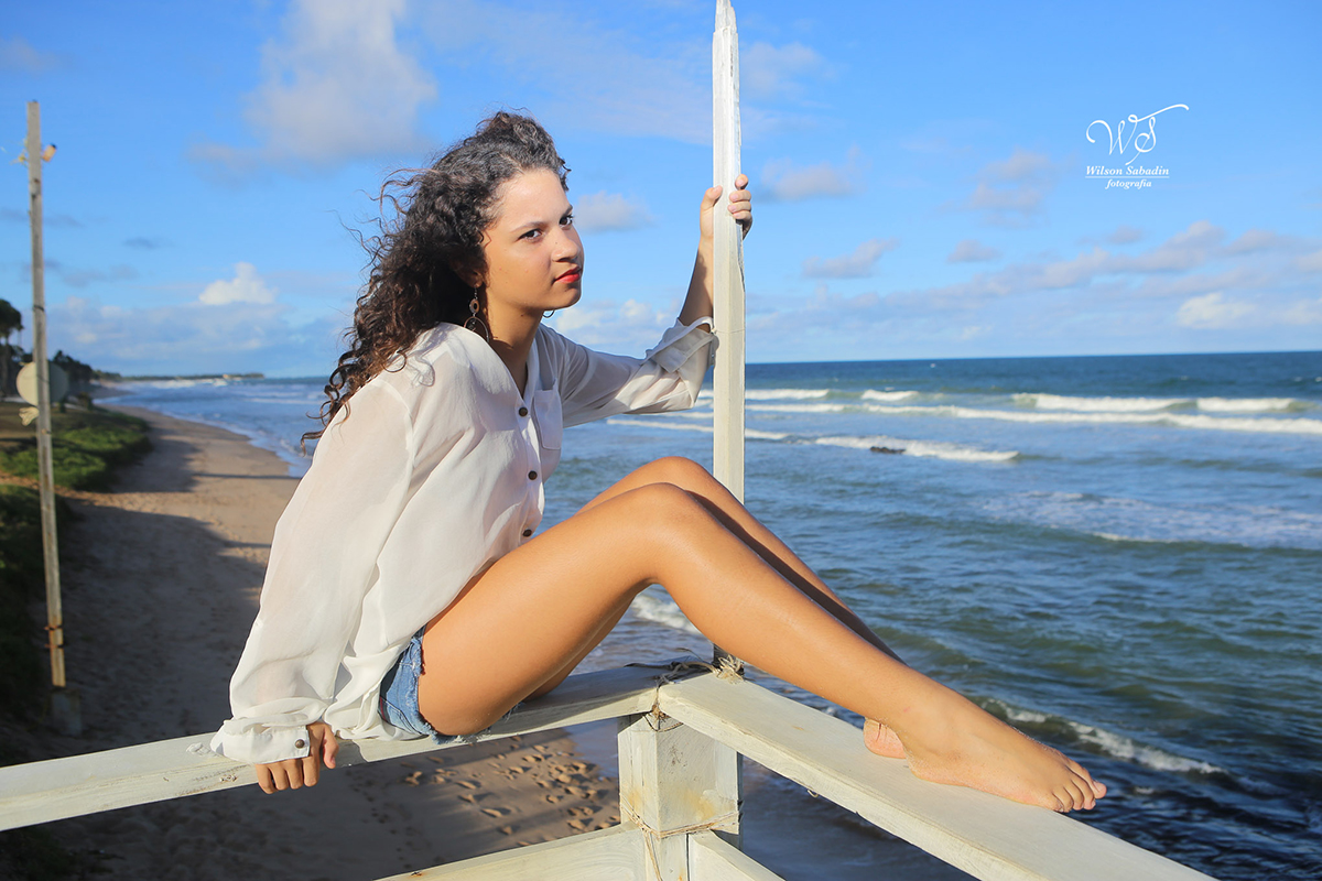 fotografia de 15 anos a debutante sentada olhando o mar