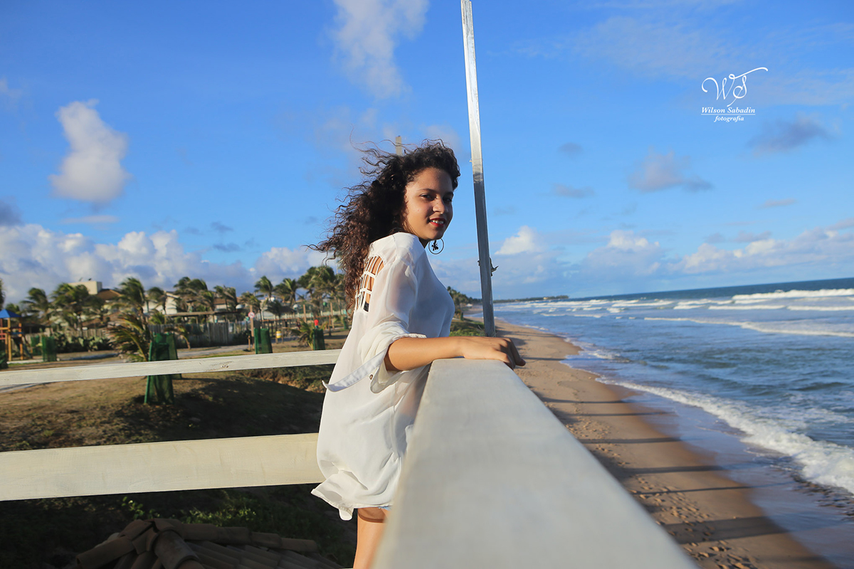fotografia de 15 anos a debutante sentindo a brisa do mar
