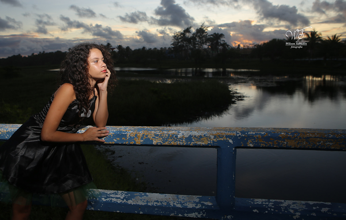 fotografia de 15 anos a debutante apreciando o entardecer sob a ponte