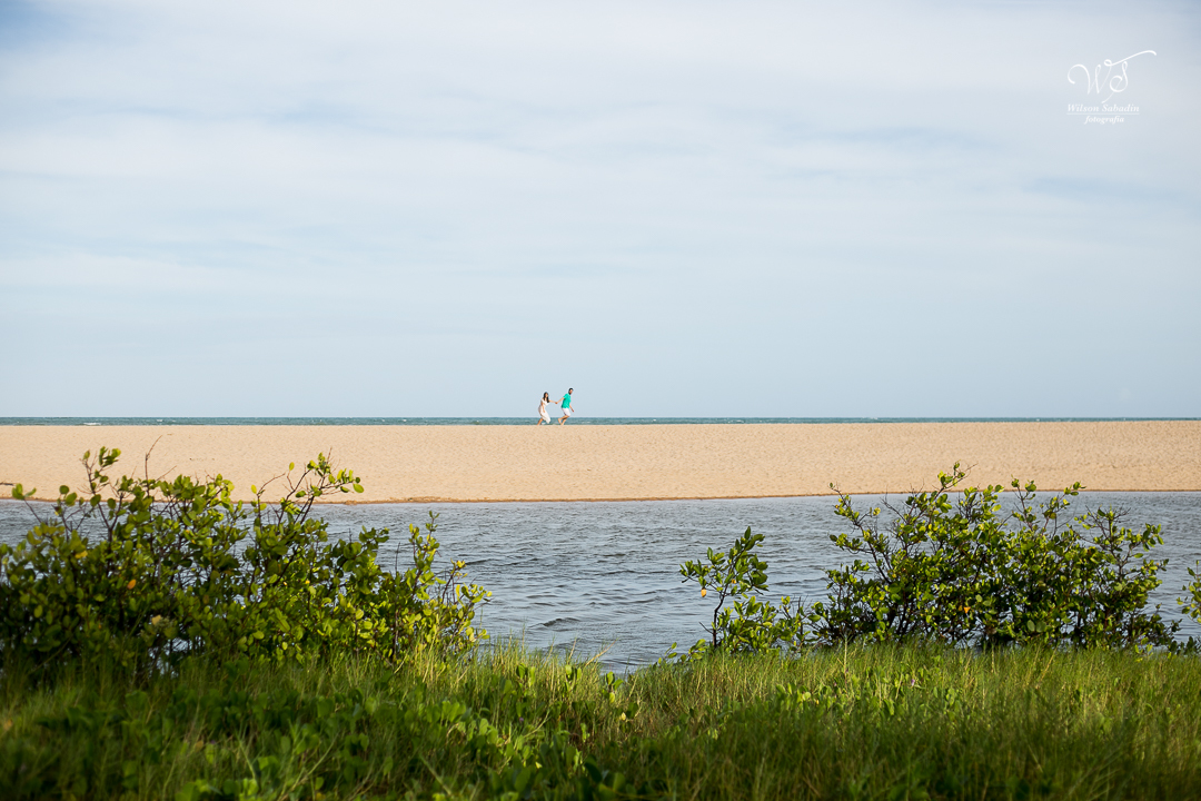 o casal andando nas areias de imbassai bahia