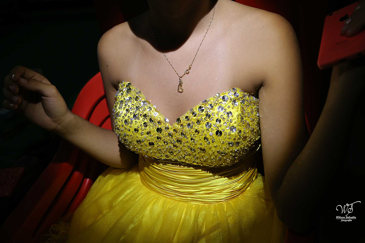 fotografia de 15 anos detalhes do vestido amarelo da debutante apreciando o entardecer sob a ponte