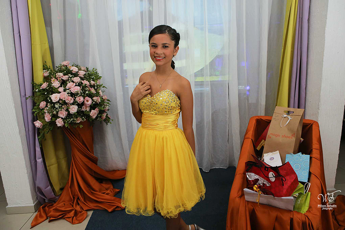 fotografia de 15 anos com o vestido amarelo da debutante apreciando o entardecer sob a ponte
