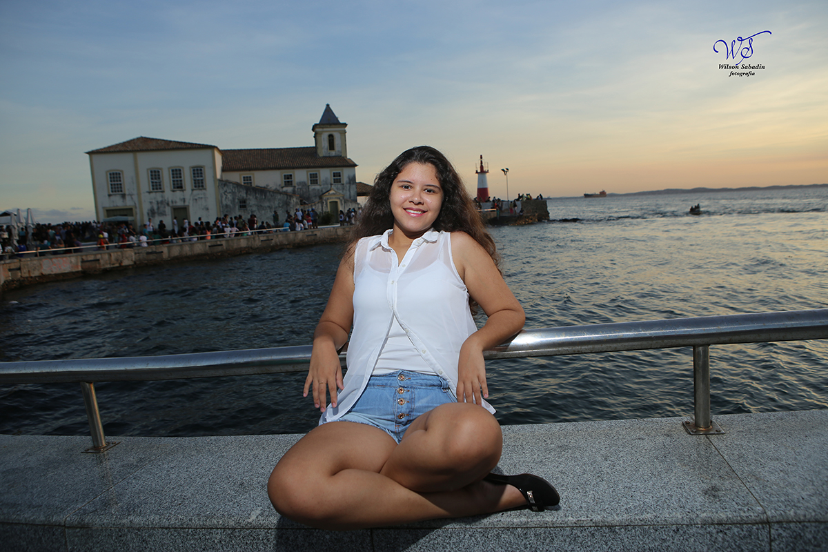 Ensaio de 15 anos, a debutante Vitória sentada enfrente a igreja do Humaitá