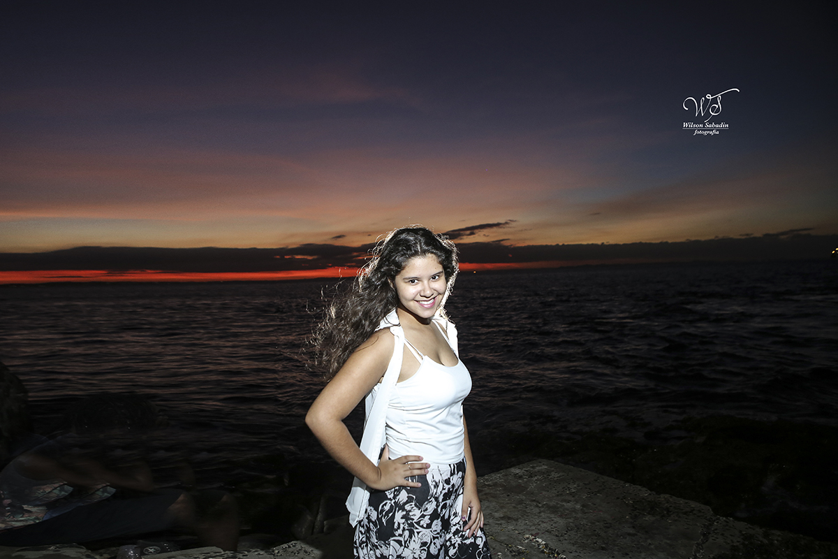 Ensaio de 15 anos, a debutante Vitória brincando no pôr do sol