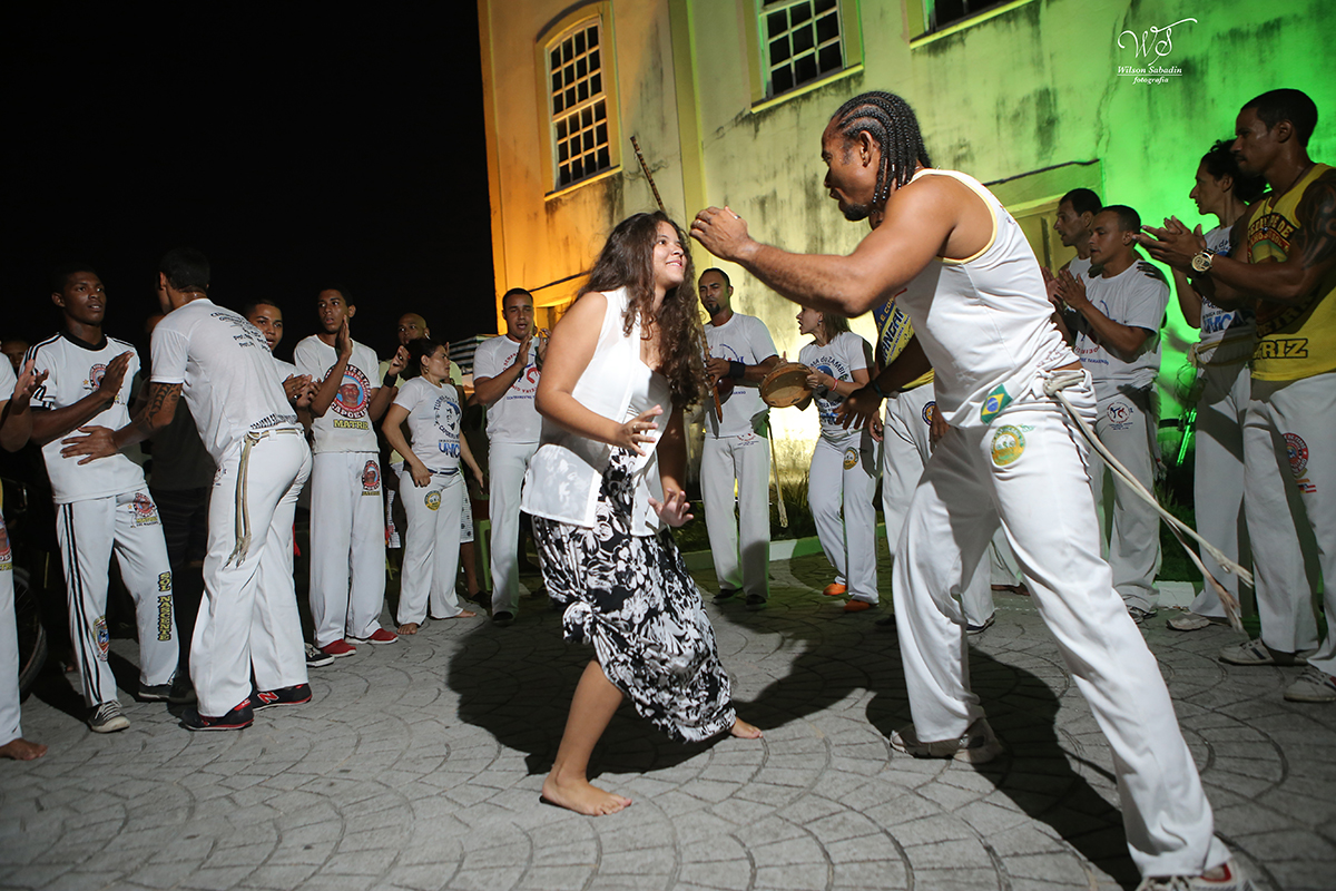 Ensaio de 15 anos, a debutante Vitória brincando capoeira enfrente a igreja do Humaitá