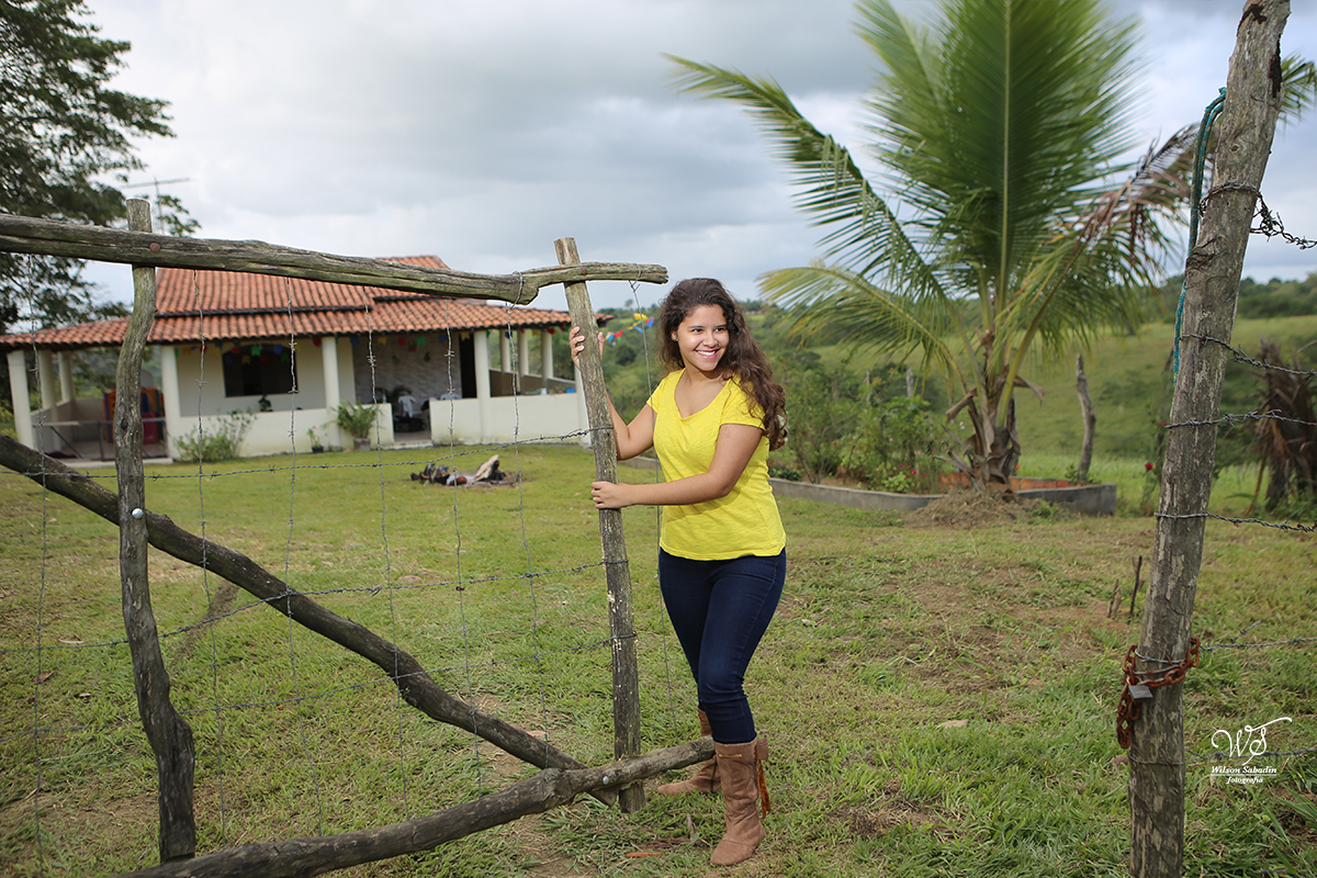 fotografia de 15 a debutante abrindo o portão da casa