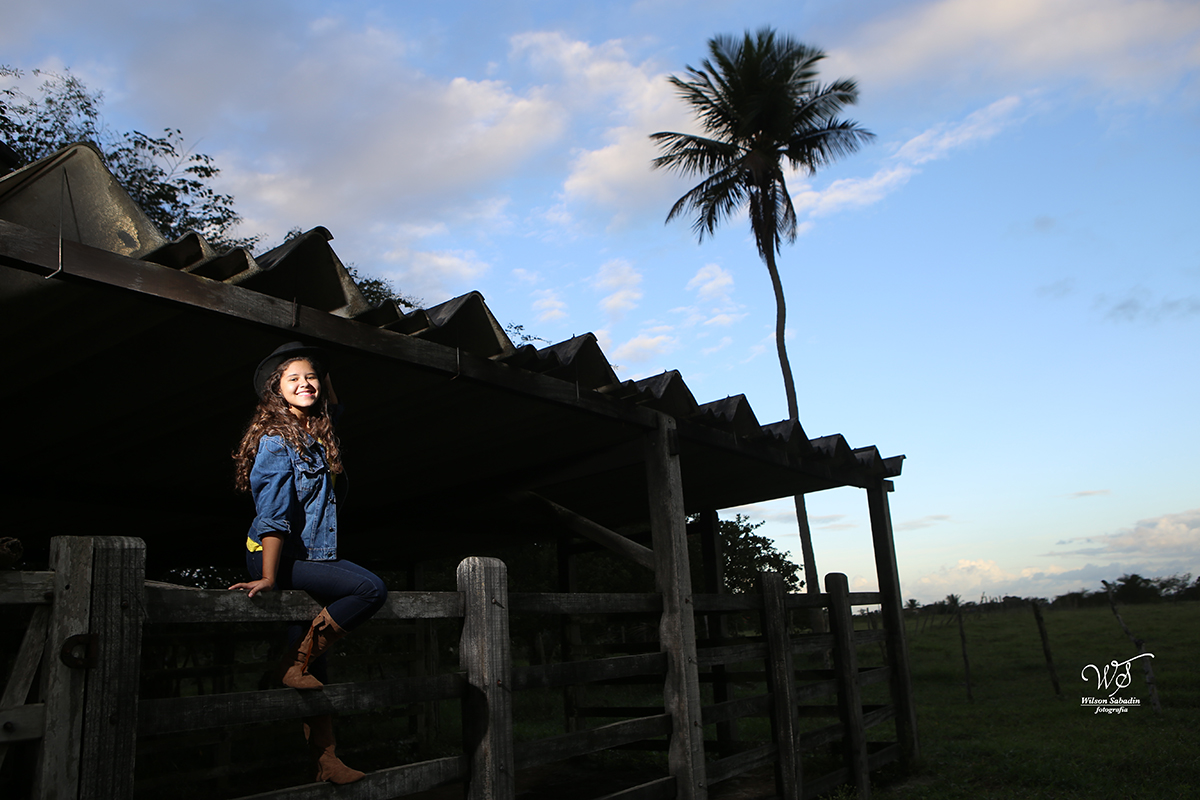fotografia de 15 a debutante no portão do curral