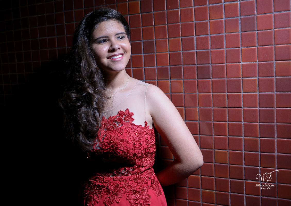 fotografia de 15 anos a debutante escostada na parede de ladrilhos