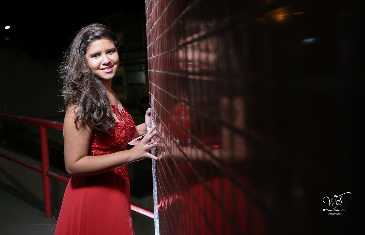 fotografia de 15 anos a debutante de frente para a parede de ladrilhos