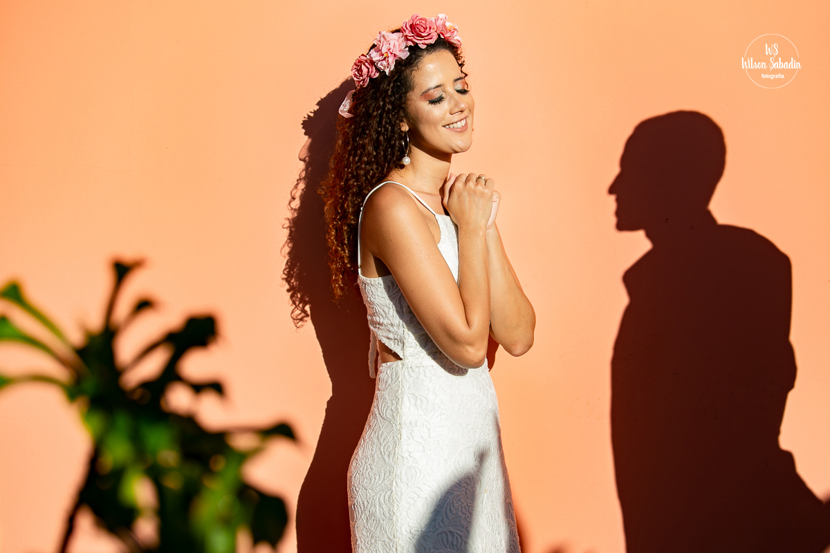 fotografia de casamento salvador bahía, casal enfrente a parede cor salmão 