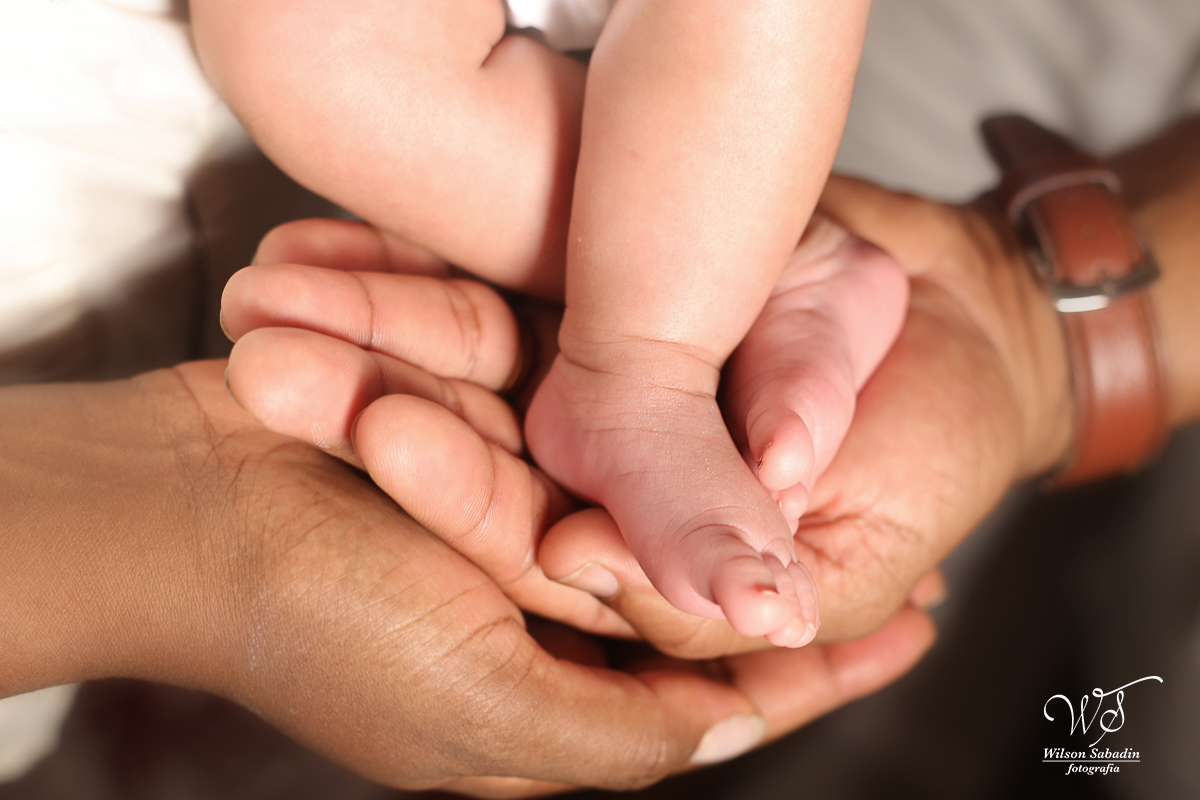 Fotografia de newborn em Salvador, detalhes o pezinho nas mãos dos pais