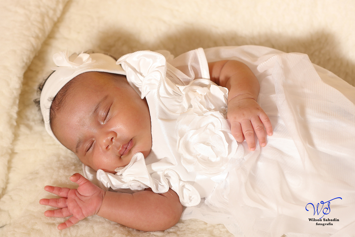Fotografia de newborn em Salvador, o bebe com vestidinho branco