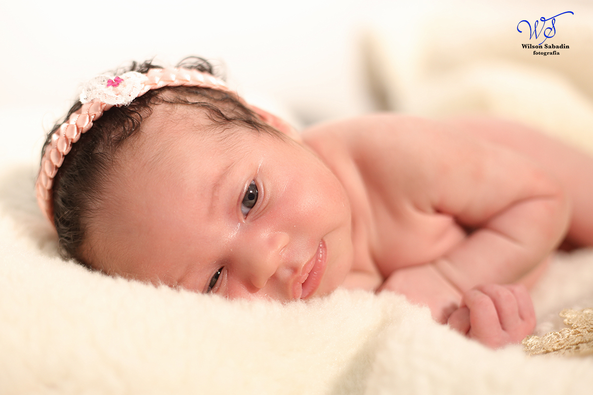 Fotografia de newborn em Salvador, o bebe dormindo com laço