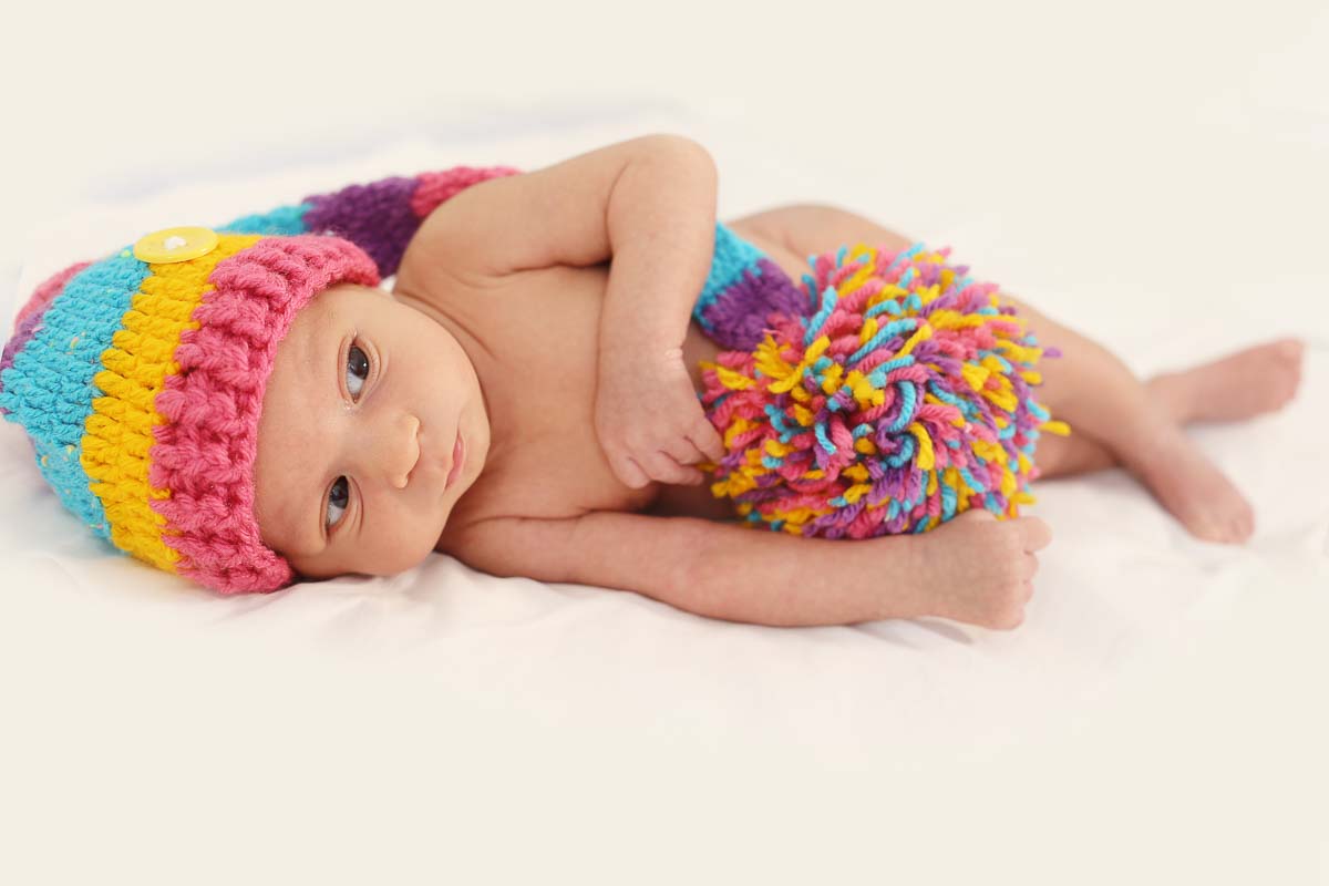 Fotografia de newborn em Salvador, o bebe com gorro colorido