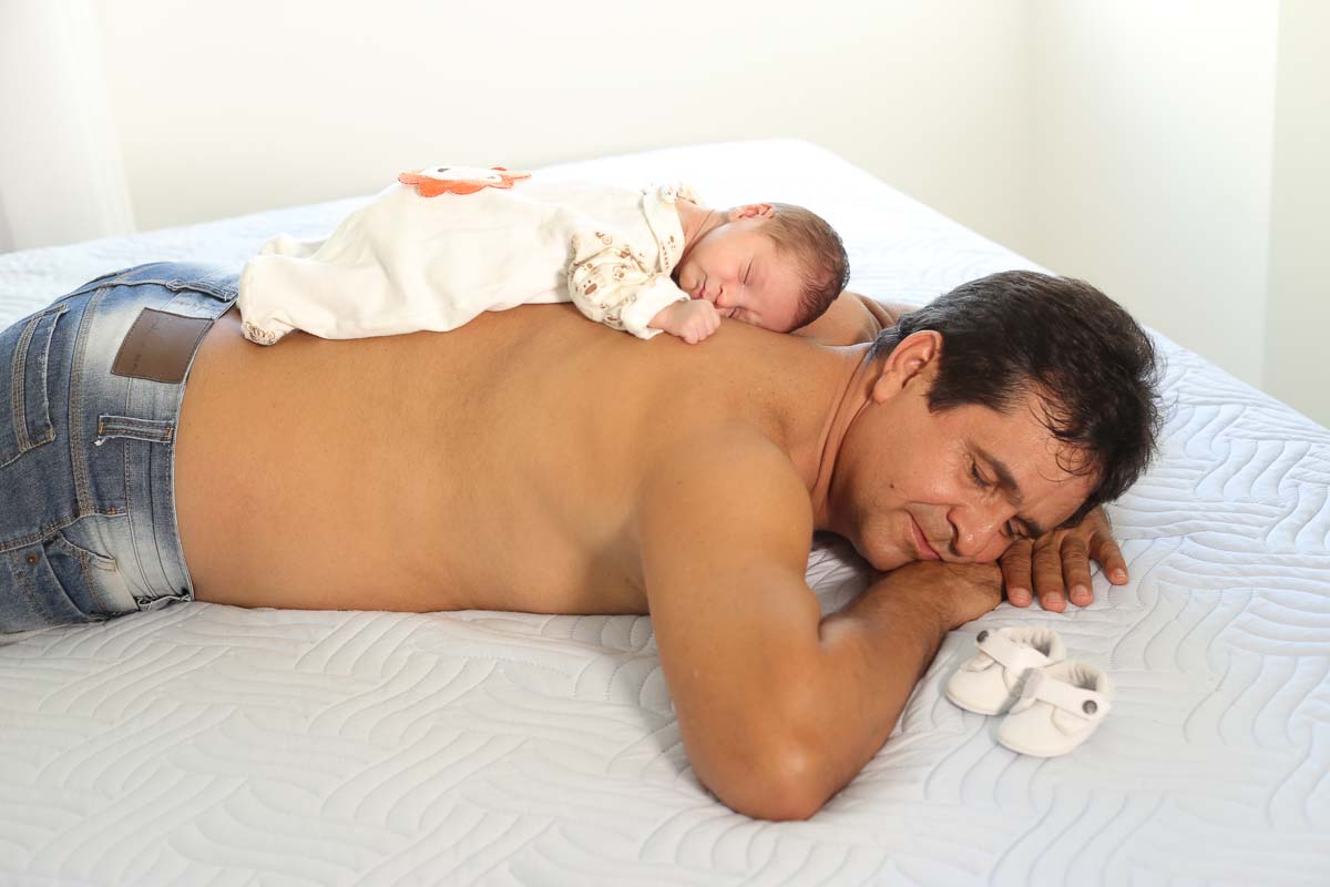 Fotografia de newborn em Salvador, o bebe deitado sob as costas do pai