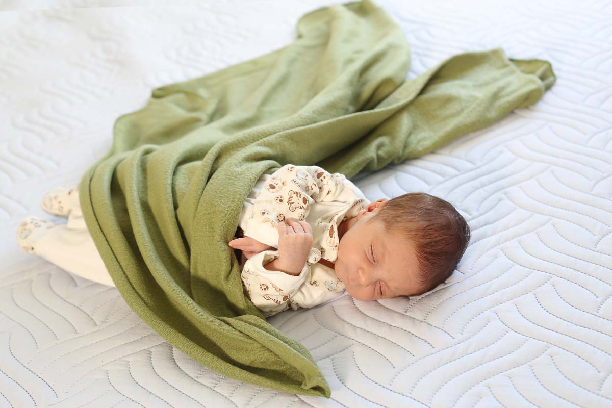 Fotografia de newborn em Salvador, o bebe com manta verde