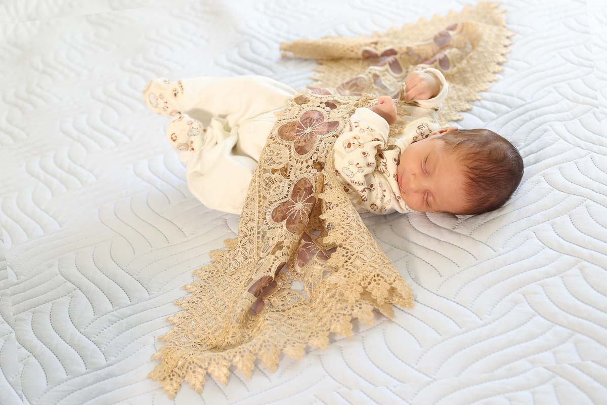 Fotografia de newborn em Salvador, o bebe e manta bordada bege