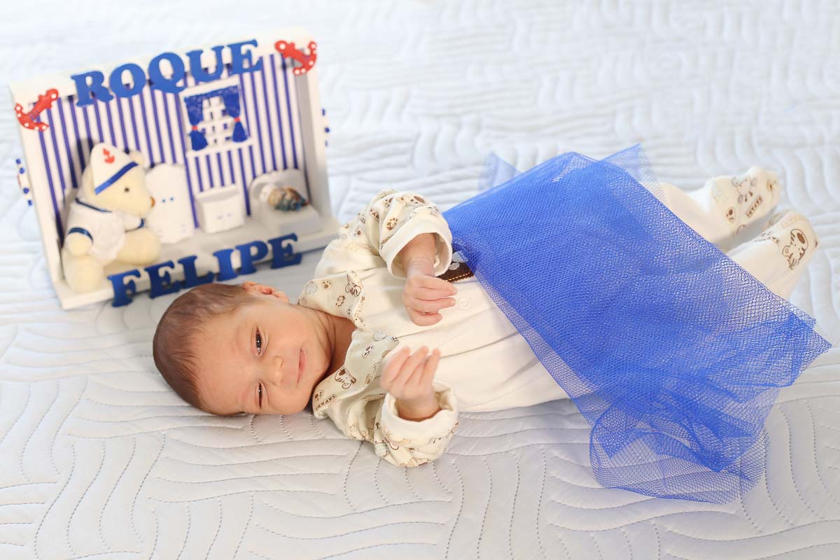 Fotografia de newborn em Salvador, o bebe mexendo as mãozinhas com seu nome inscrito na casinha