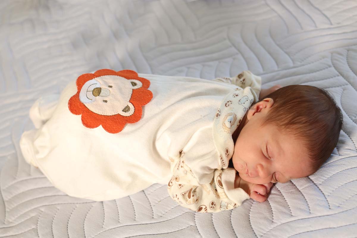 Fotografia de newborn em Salvador, o bebe com macacão bege e com figura de urso