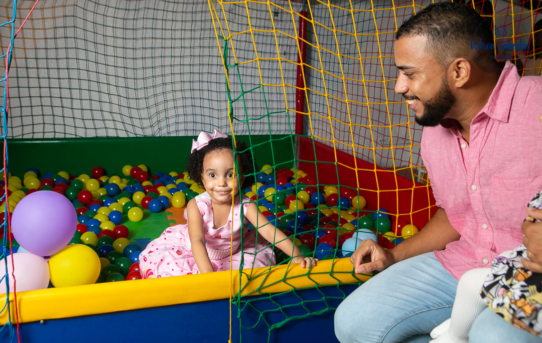festa infantil em salvador bahía, o pai observando sua pequena na piscina de bolinhas coloridas