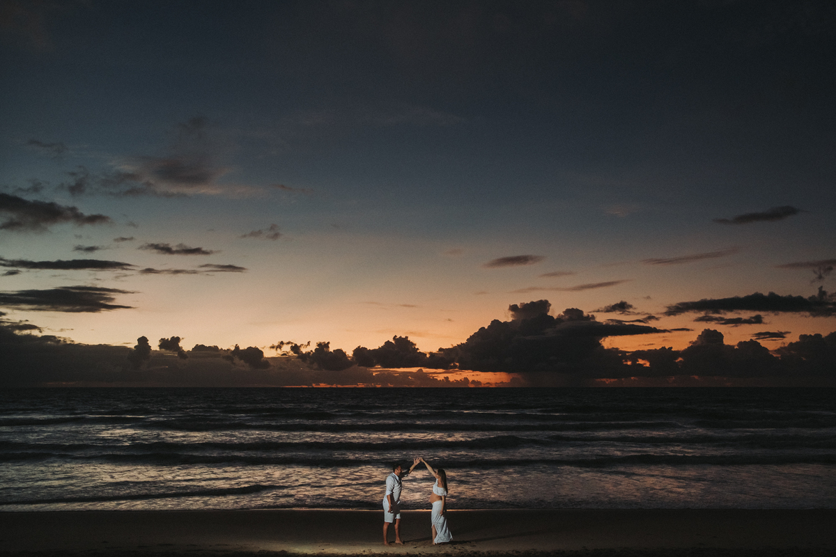 Gestante no nascer do sol na praia