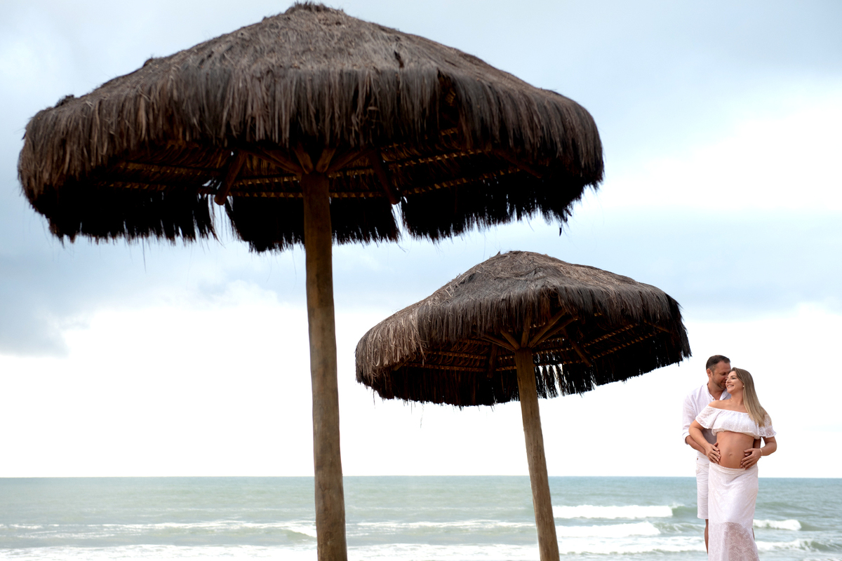 Ensaio de gestante com marido em frente a praia com fotos criativas