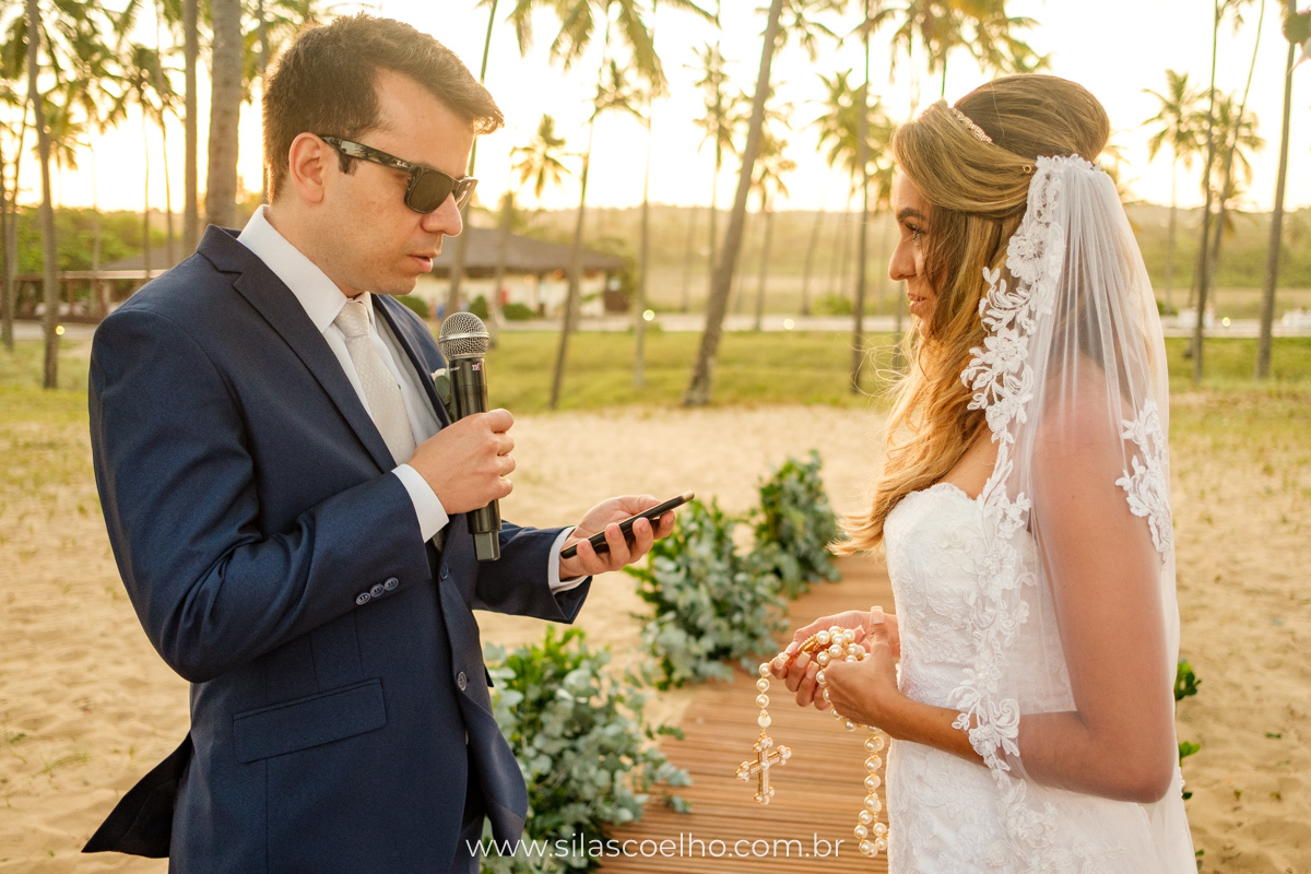 Noiva no altar lendo os votos para noivo no por do sol no Grand Palladium Imbassaí Resort & SPA na Bahia para seu casamento a dois