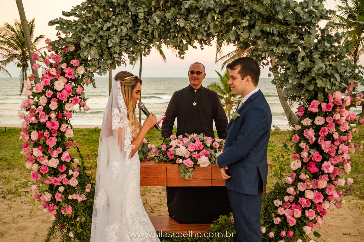 Noiva no altar lendo os votos para noivo no por do sol no Grand Palladium Imbassaí Resort & SPA na Bahia para seu casamento a dois